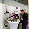 Messestand mit Schriftzug PohlCon, Mitarbeiter und Besucher sowie Ausstellungsstücken