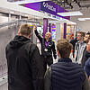Messestand mit dem Schriftzug PohlCon und mit Besuchern an einem Exponat