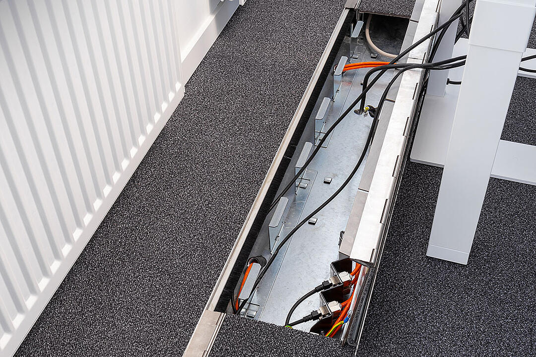 Das in den Boden eingelassene Kanalsystem für Kabel, aufgeklappt, in einem Büro.