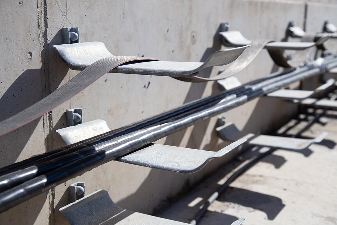 Detailaufnahme der Kabeltragwannen an Bahnschienen.