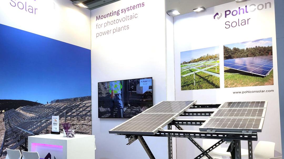 PohlCon Messestand auf der Intersolar. Davor stehen zwei Solarpaneele.