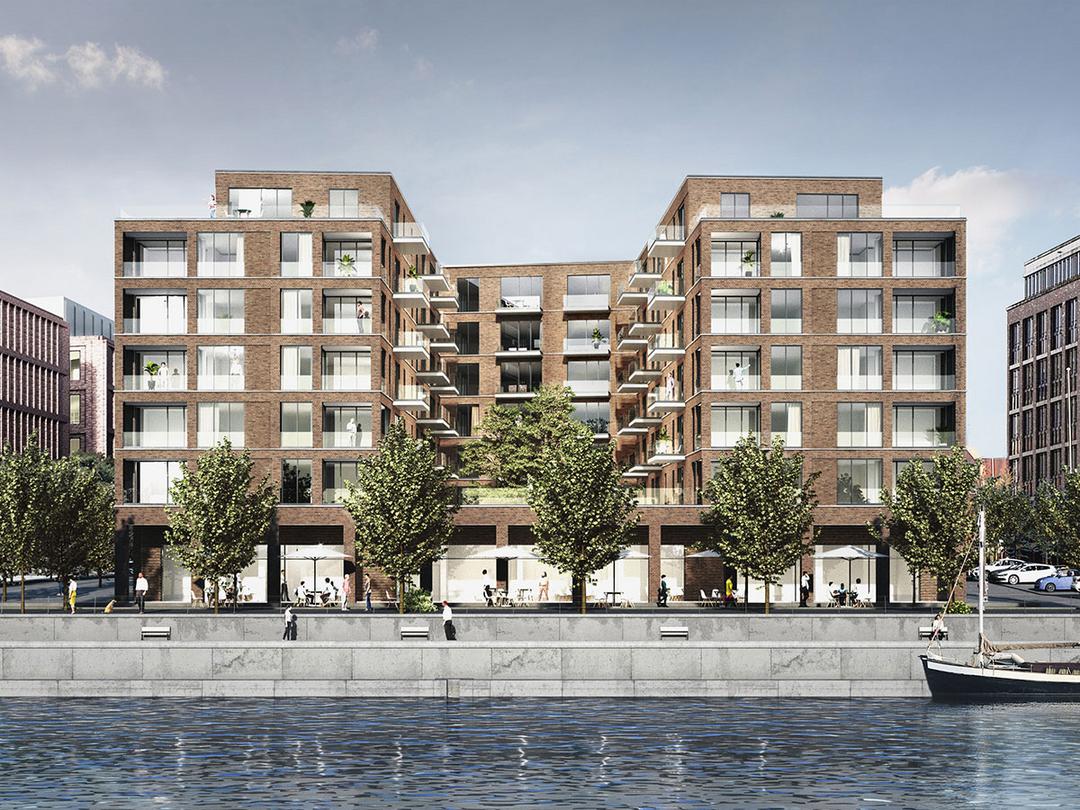 Modernes, mehrstöckiges Wohn- und Geschäftsgebäude aus Backstein an Uferpromenade mit Bäumen, Menschen und einem Segelboot im Wasser