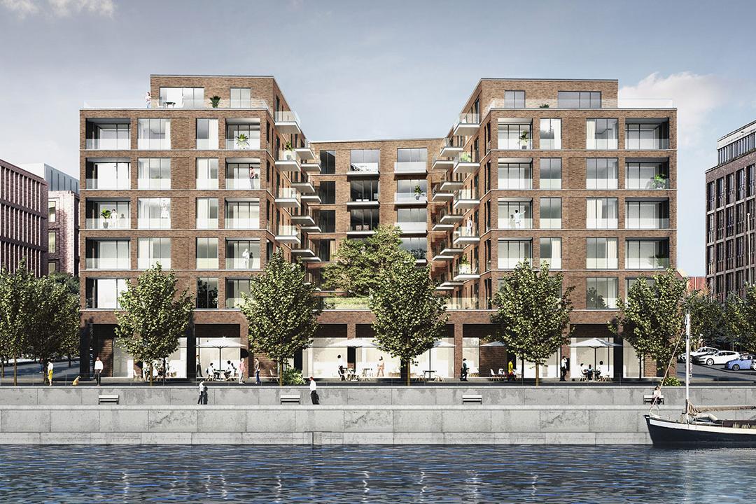 Modernes, mehrstöckiges Wohn- und Geschäftsgebäude aus Backstein an Uferpromenade mit Bäumen, Menschen und einem Segelboot im Wasser