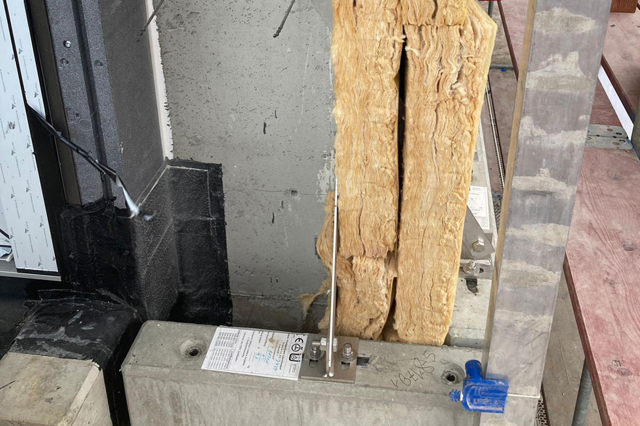 Detailaufnahme auf einer Baustelle mit Mineralwolle-Isolierung, Verblenderkonsolen an der Wand und Betonbauteil