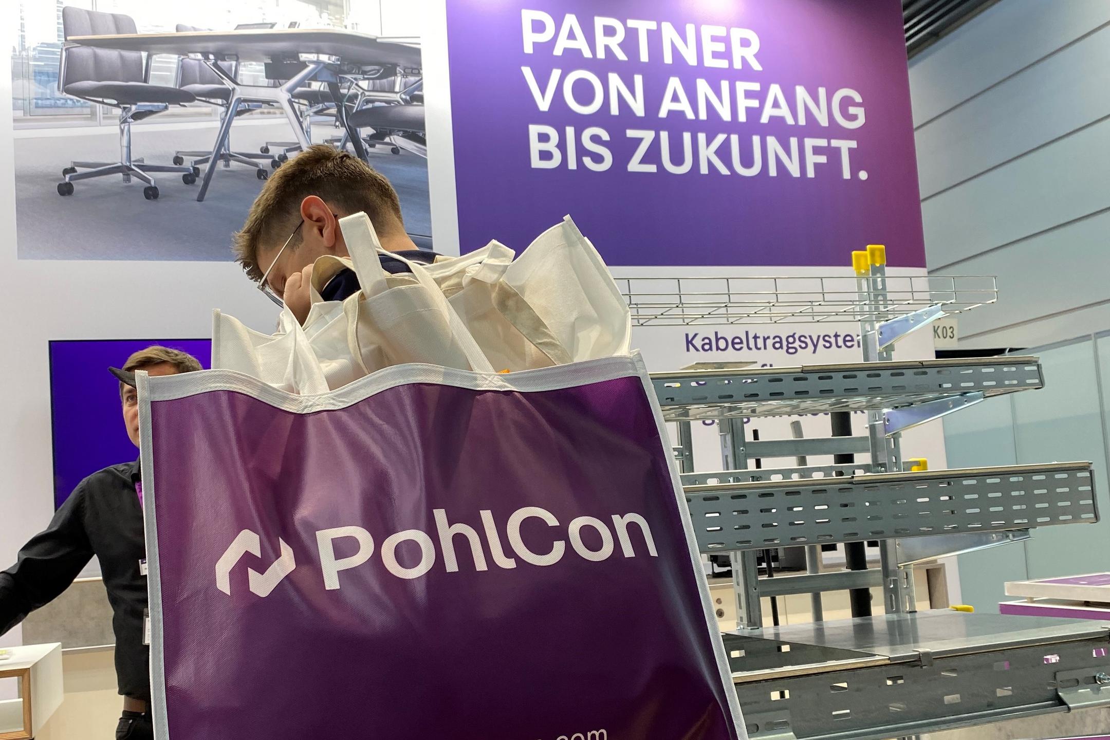 PohlCon-Messestand mit Publikumsverkehr, Mann mit großer Tasche