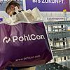 PohlCon-Messestand mit Publikumsverkehr, Mann mit großer Tasche