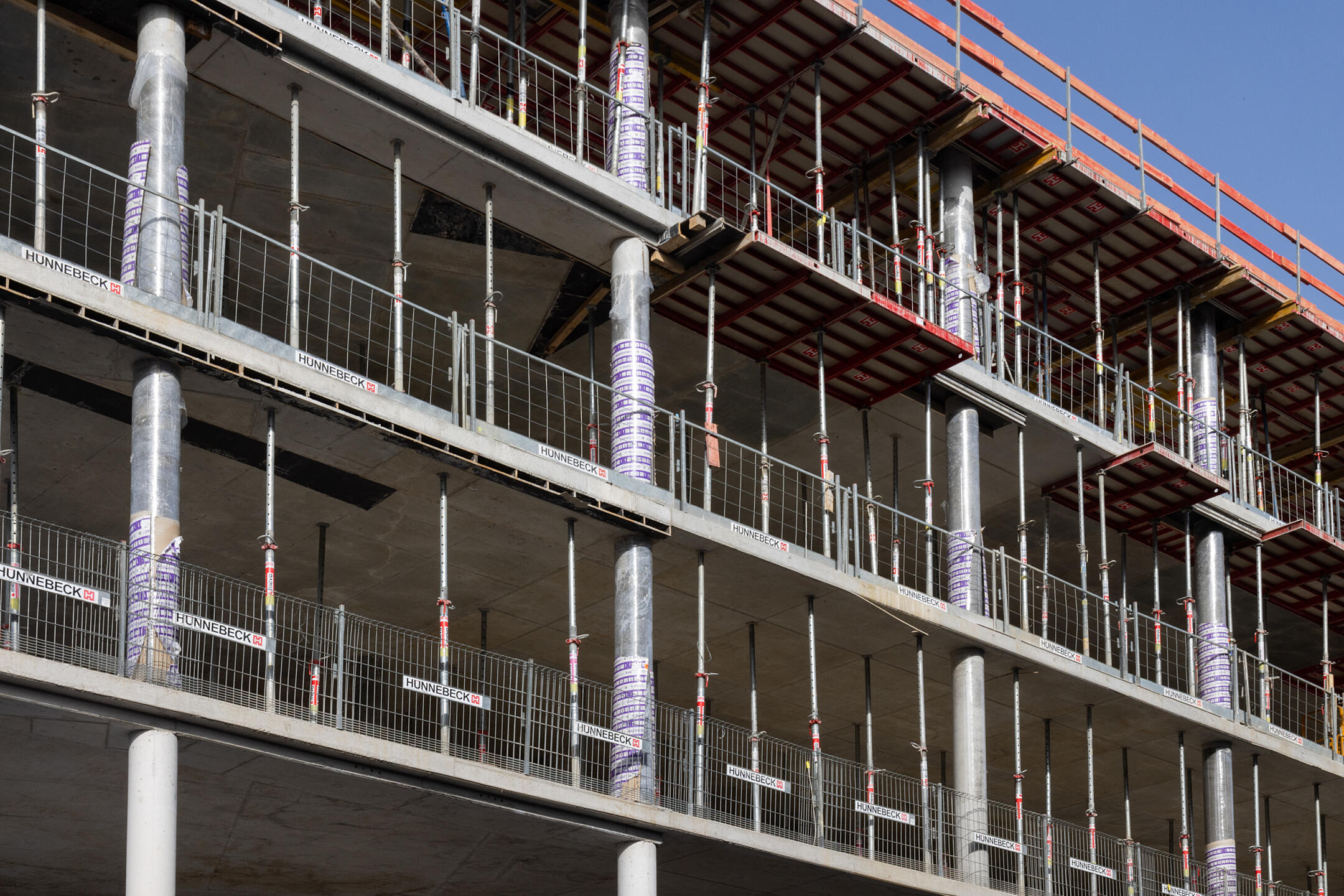 Außenansicht einer Baustelle in der Rohbauphase, eingeschalte und freie Betonstützen sind sichtbar