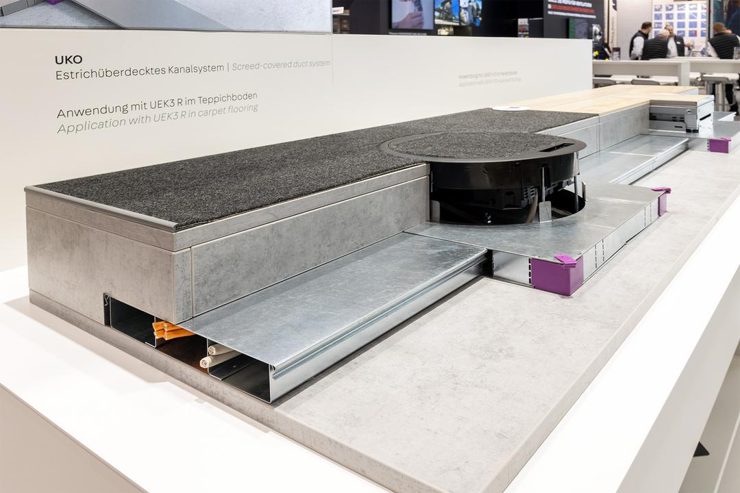 Unterflurkanal aus Metall als Exponat mit runder Bodendose für Strom und Daten