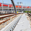 Bahngleise und die S-Bahn im Hintergrund bei Sonnenschein.