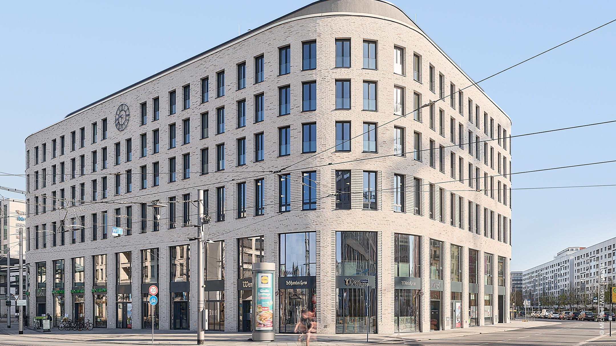 Außenansicht des Haus Postplatz in Dresden mit heller Fassade vor blauem Himmel