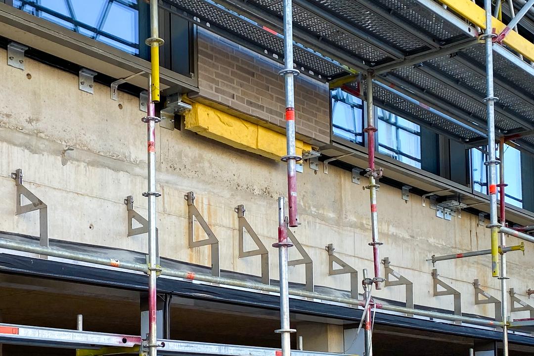 Verblenderkonsolen an Betonwand mit Baugerüst