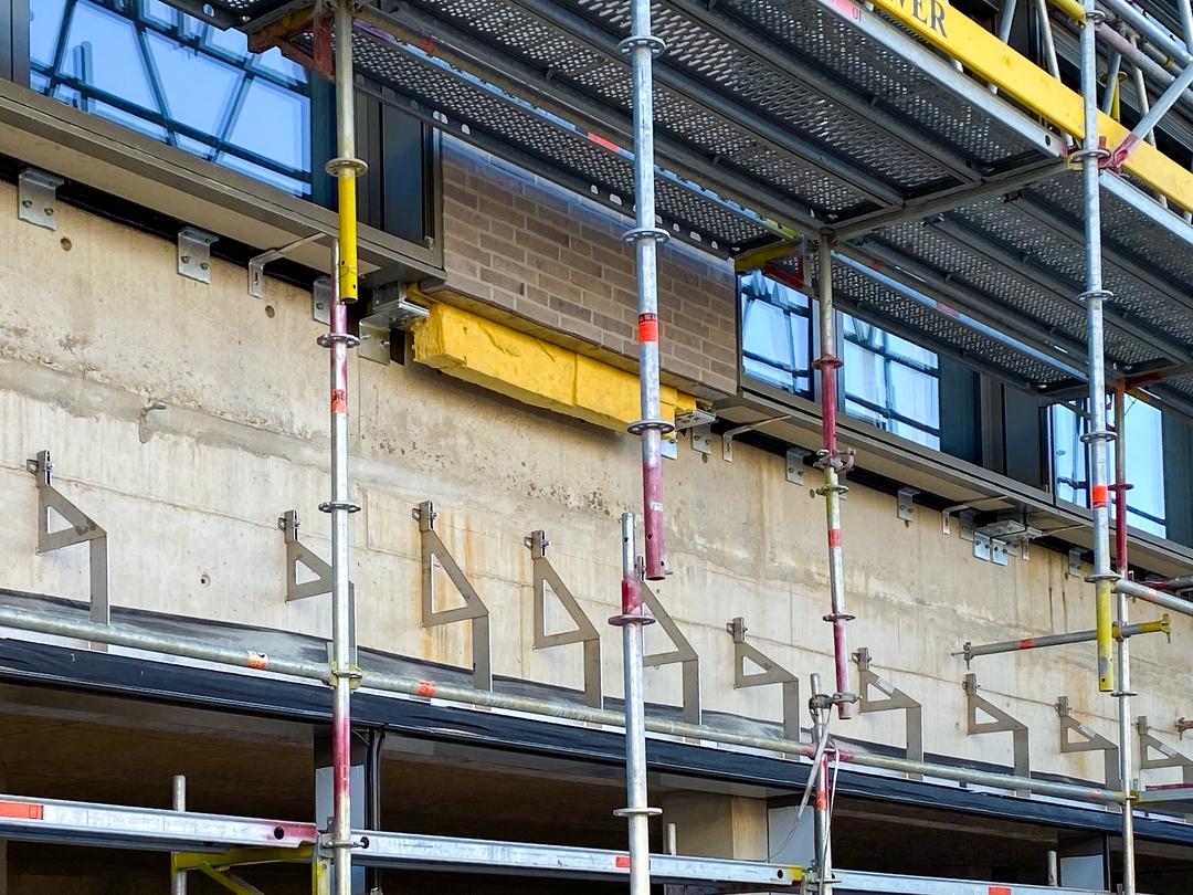 Verblenderkonsolen an Betonwand mit Baugerüst