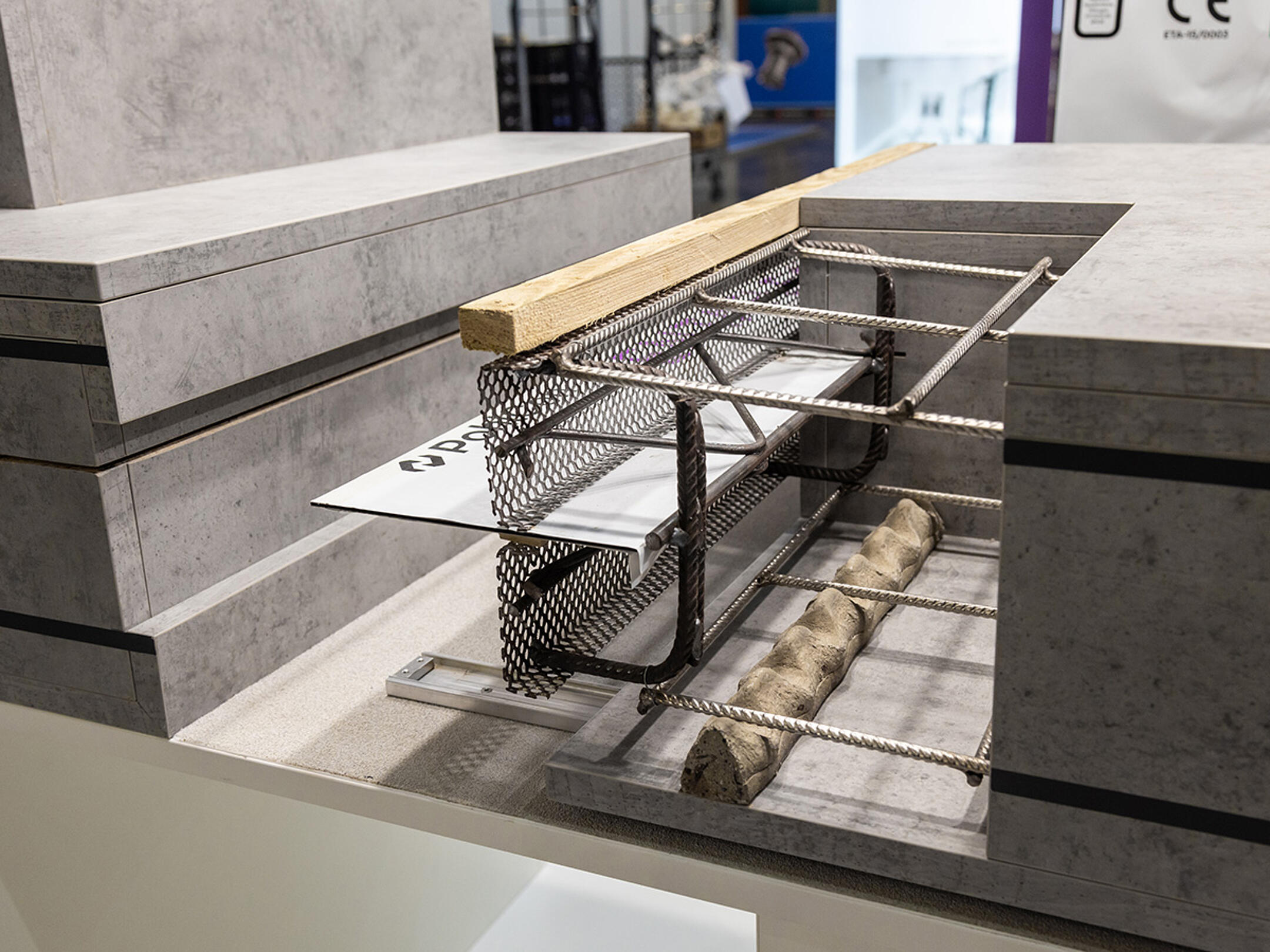 Ausstellungsmodell eines Betonbauteils mit Bewehrung, Schalungselementen und Fugenblech.